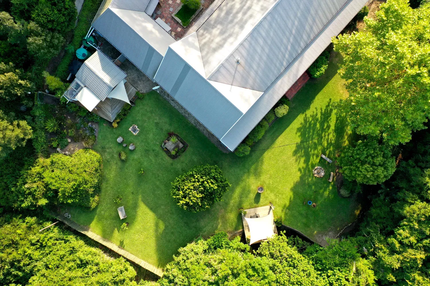 Aerial view of a house with a large green yard and trees
