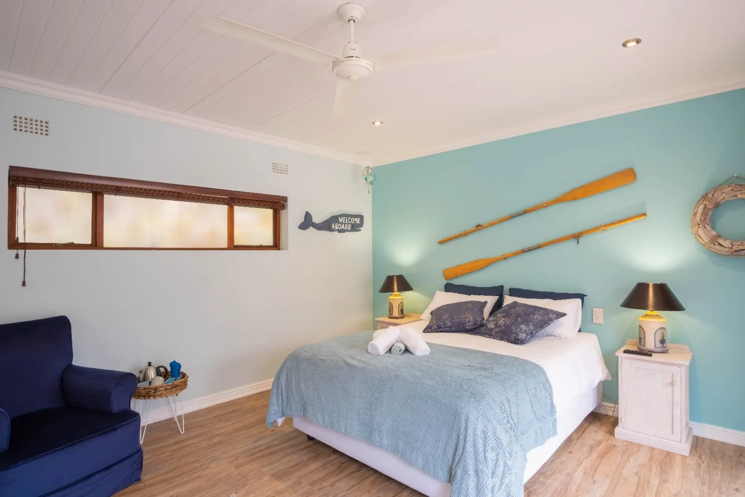 Cozy bedroom with nautical decor ceiling fan and oars on the wall