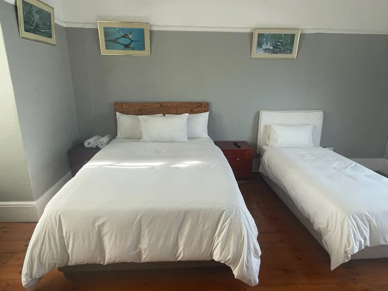 Bedroom with a double bed and a single bed on wooden floor