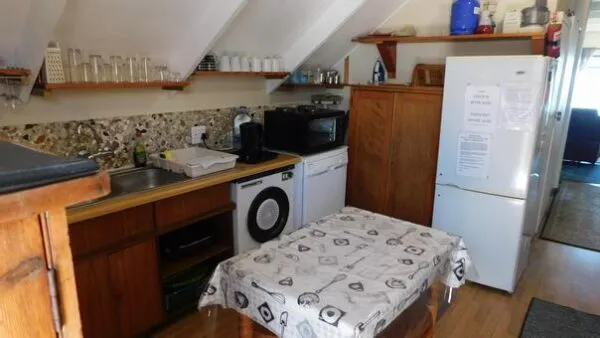 Cozy kitchen with wooden cabinets white appliances and a patterned tablecloth