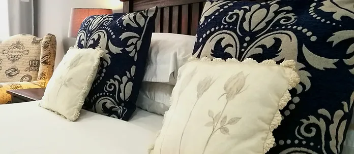 Decorative pillows on a bed with intricate patterns in a bedroom setting