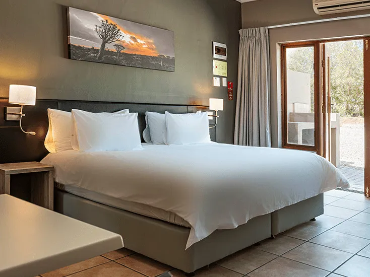 Neat bedroom with a large bed wall art and sliding glass doors