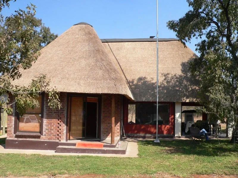 Traditional thatchedroof house with brick walls in a garden setting