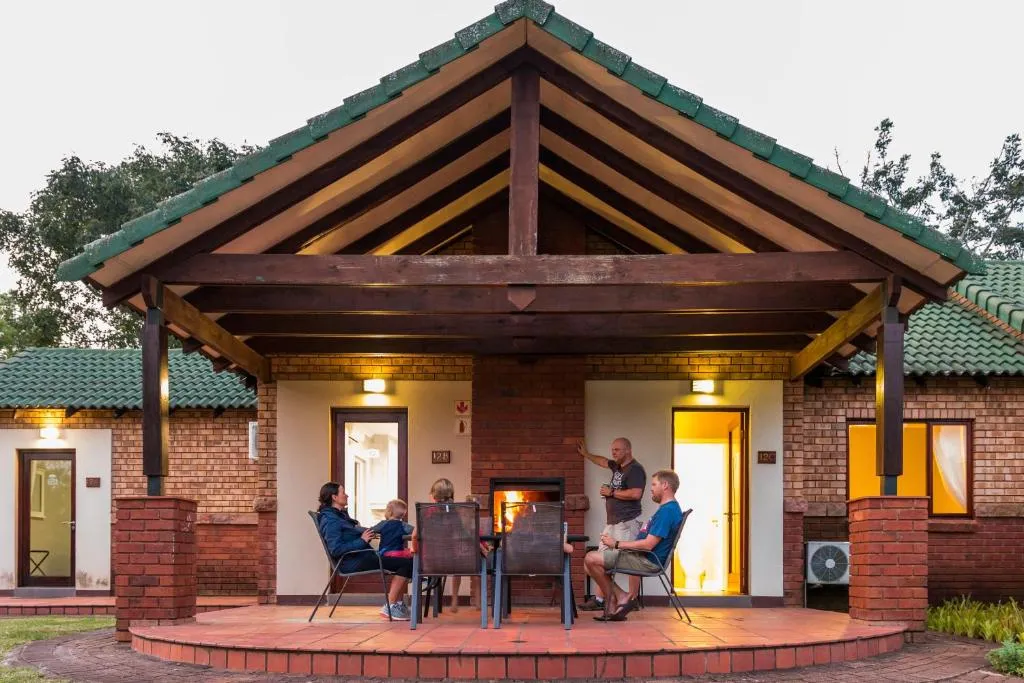 People gathered around a table under a patio with a brick fireplace
