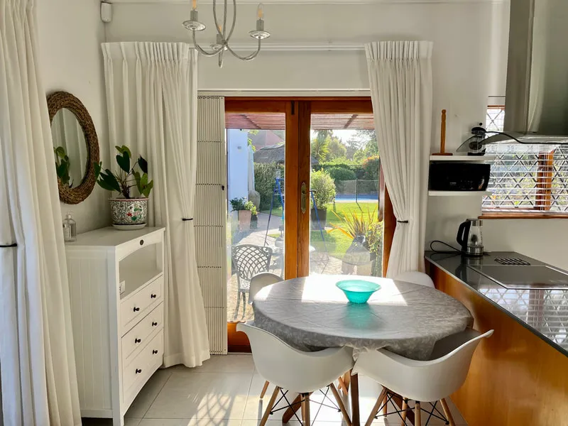 Bright kitchen with dining table large windows and garden view