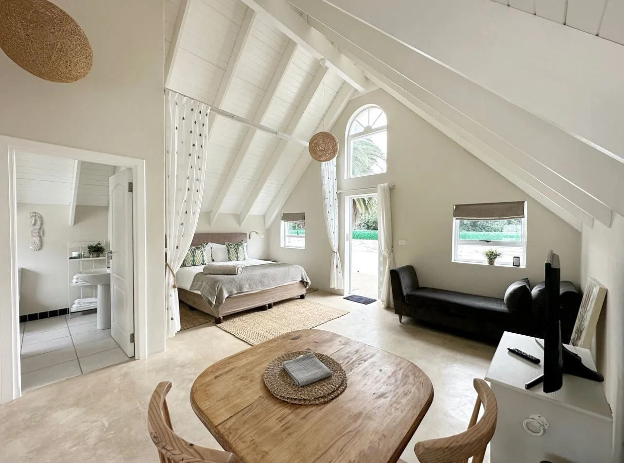 Cozy attic bedroom with slanted ceilings bed seating area and dining table