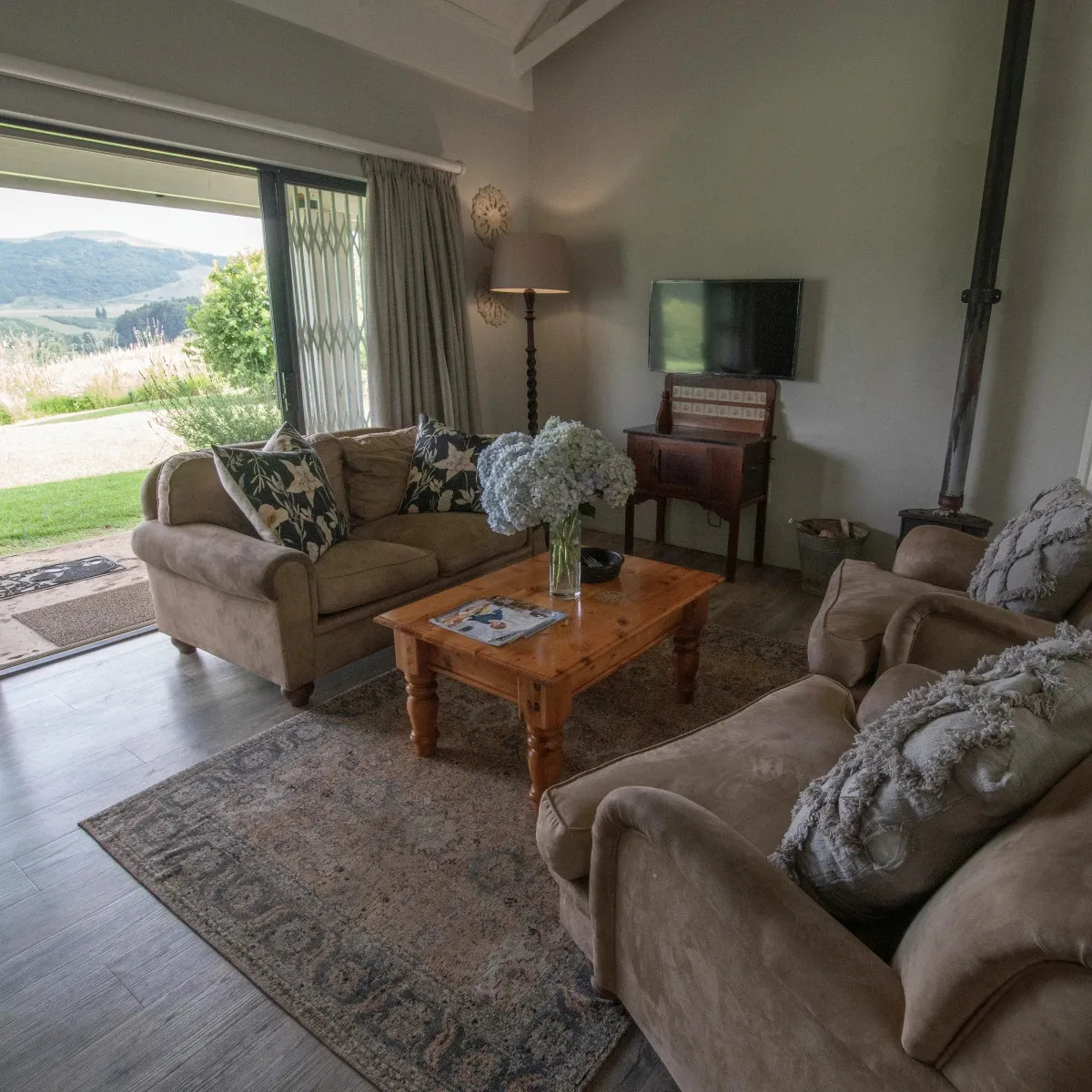 Cozy living room with sofas coffee table TV and open patio view