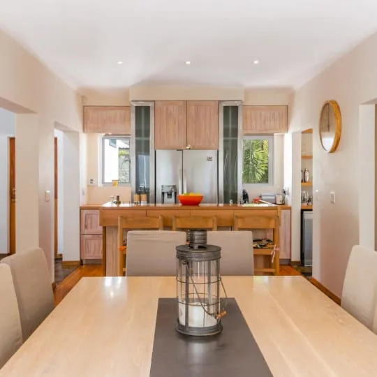Wooden dining table with chairs in a modern kitchen with a lantern centerpiece