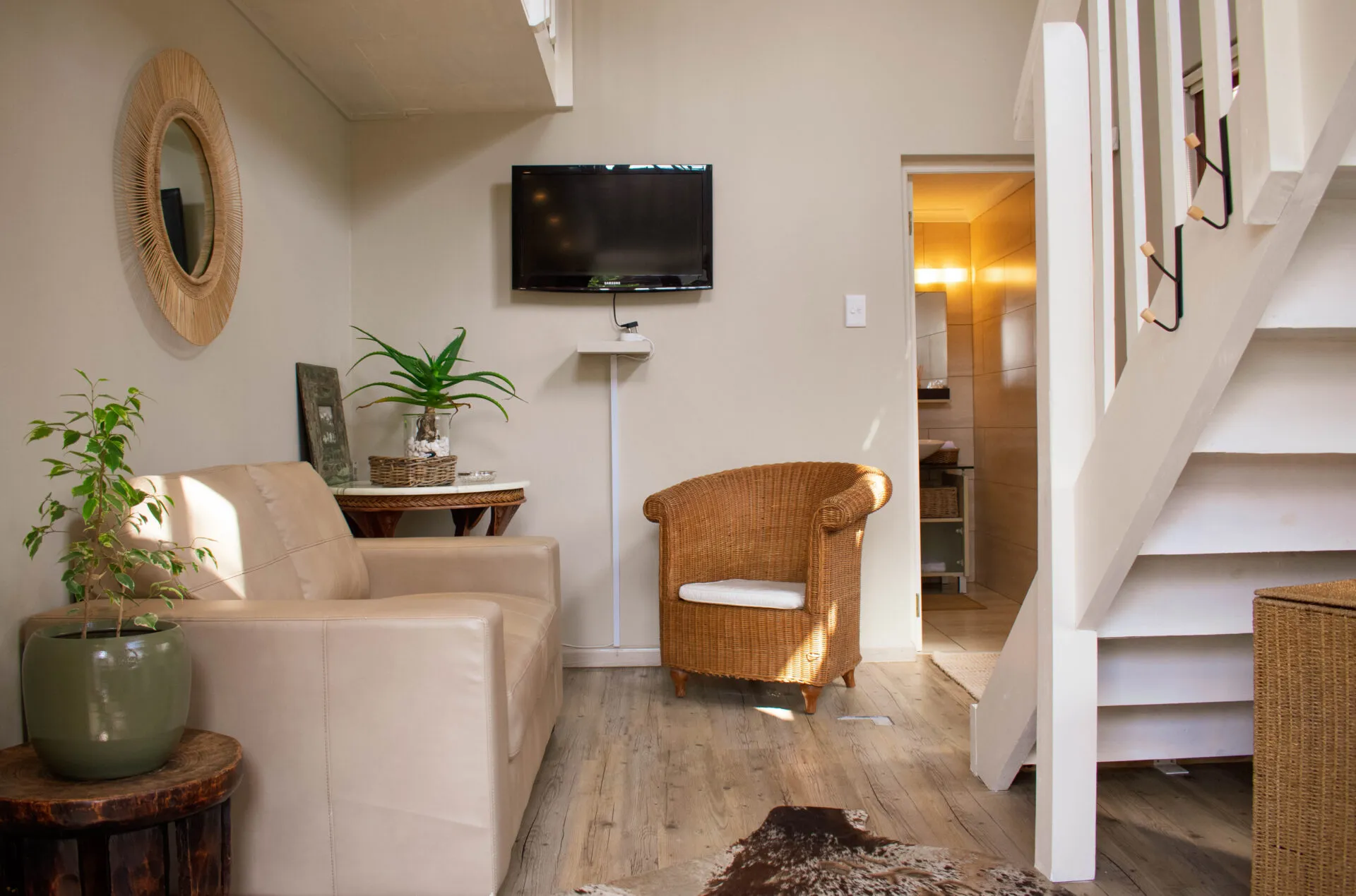 Cozy living room with armchair sofa TV and staircase leading upstairs