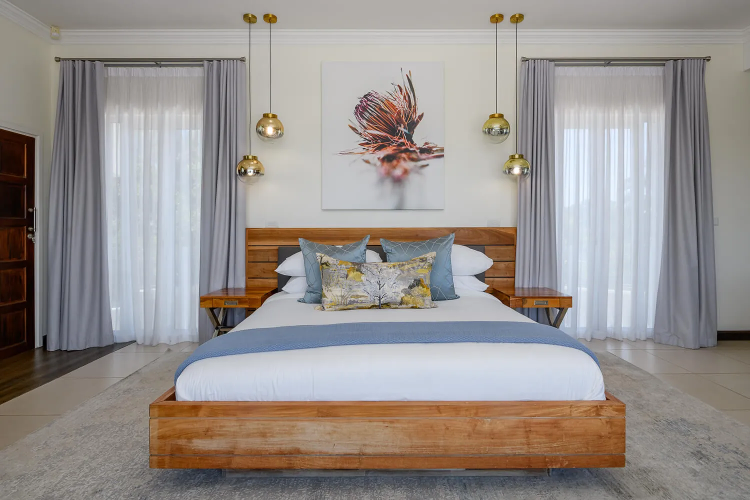 Modern bedroom with large bed wooden frame and three hanging pendant lights