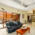 Living room with black sofa wooden table and open sliding doors to patio