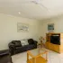 Living room with black sofa wooden TV stand and ceiling fan