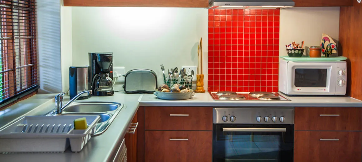 Modern kitchen with red tile backsplash stainless steel appliances and wooden cabinets