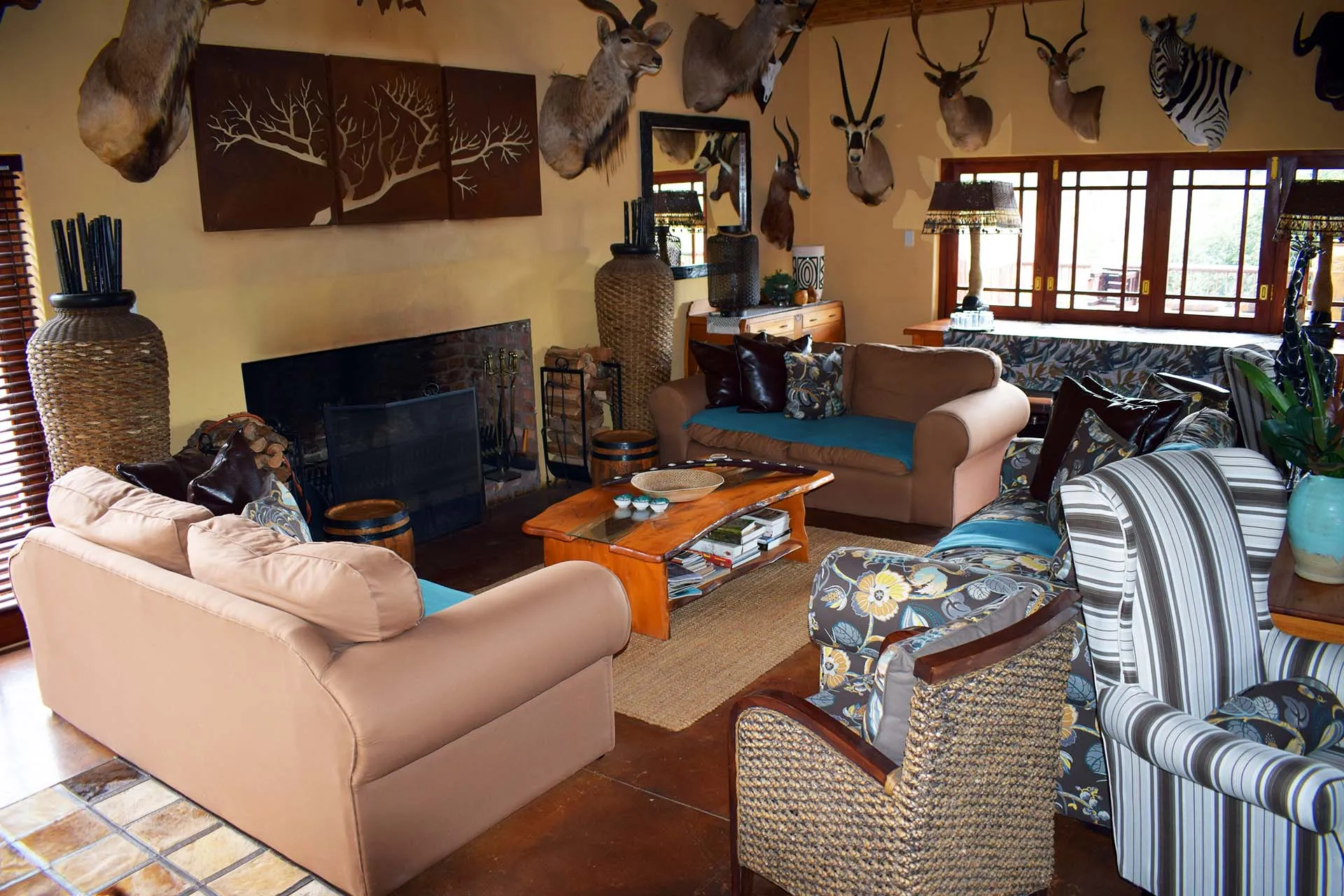 Cozy living room with animal heads on walls sofas and a fireplace