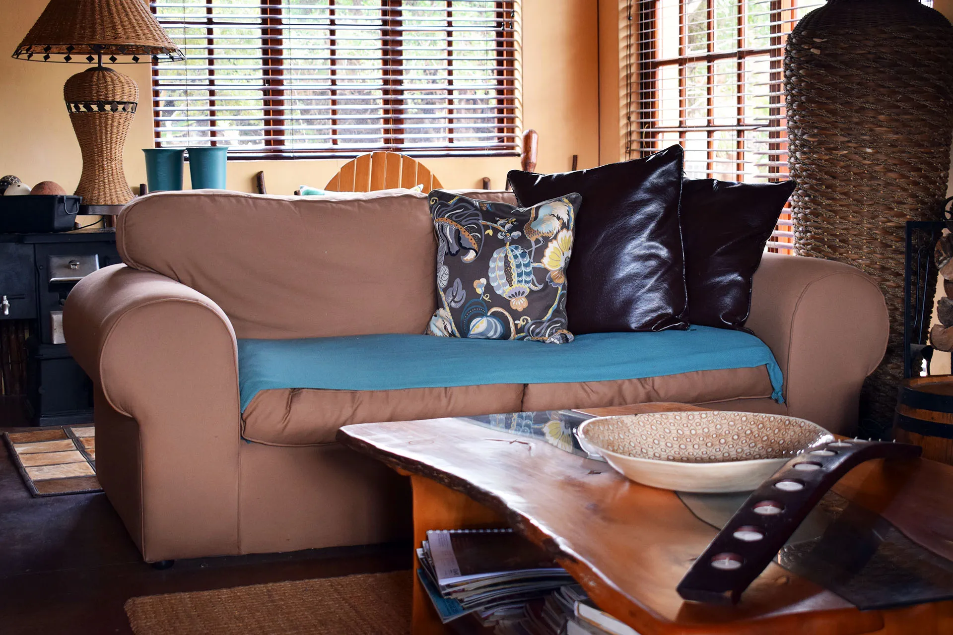 Brown sofa with blue throw and pillows in a cozy living room