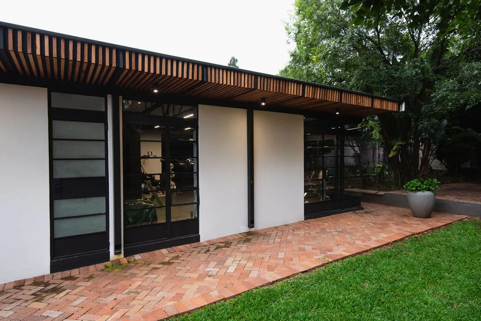 Modern building with large windows brick pathway and green lawn