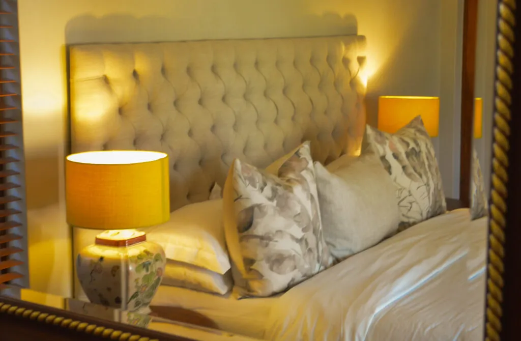Cozy bedroom with a large bed pillows and yellow bedside lamps