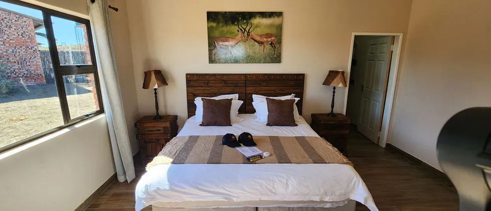 Cozy bedroom with a large bed two bedside tables and a nature painting