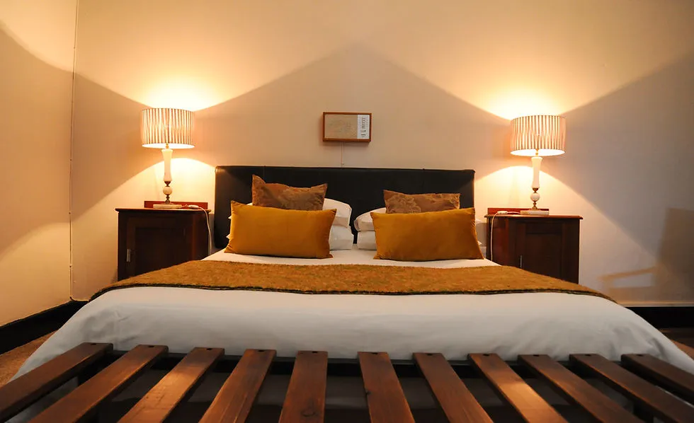 Cozy bedroom with a large bed two bedside lamps and wooden furniture