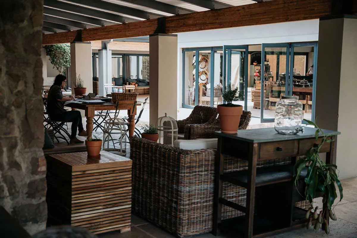 Outdoor seating area with wooden furniture and potted plants in a rustic setting