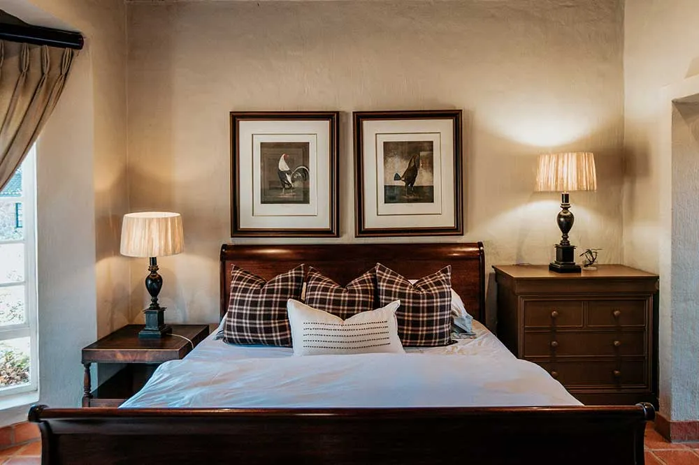 Cozy bedroom with a large bed two lamps and two framed pictures on the wall