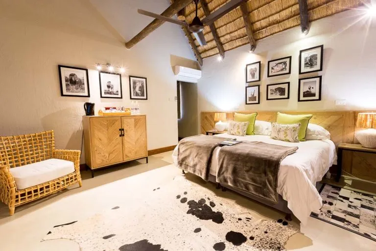 Cozy bedroom with wooden furniture wicker chair and blackandwhite wall photos