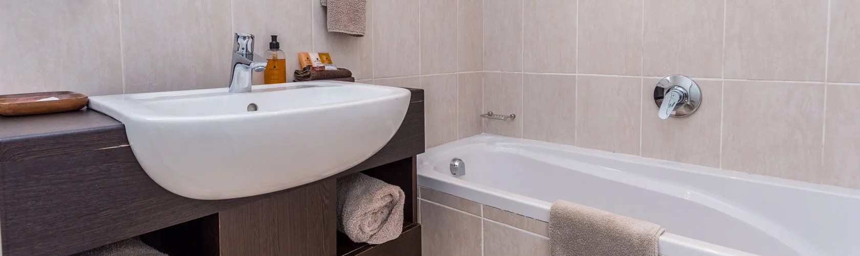 Modern bathroom with white sink bathtub and beige tiles