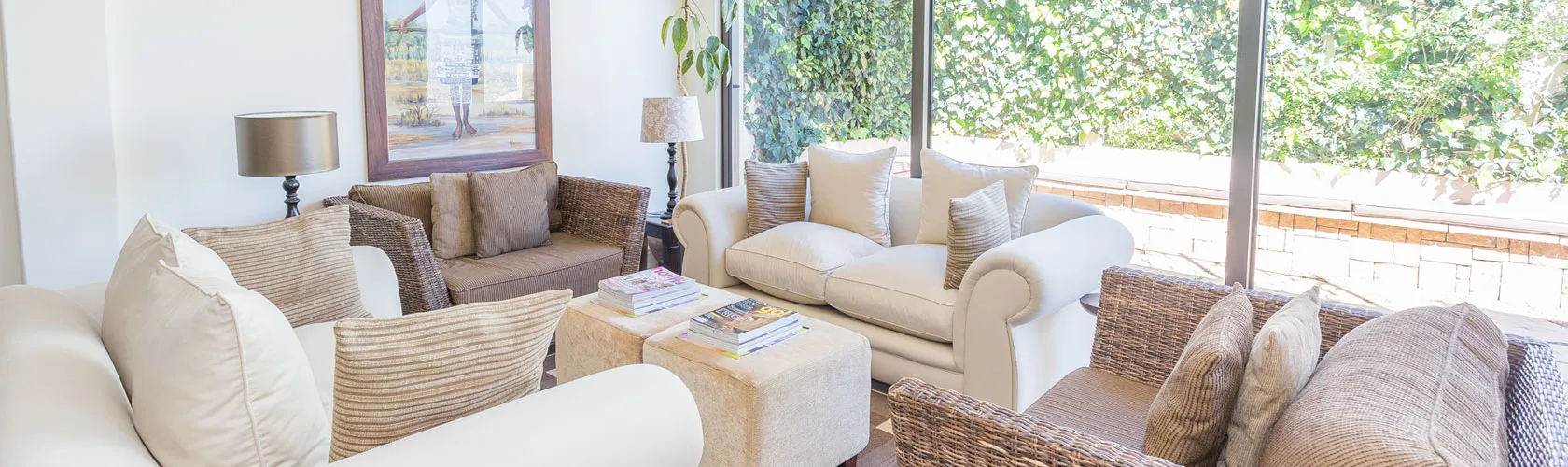 Cozy living room with sofas a coffee table and large windows overlooking greenery