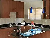 Modern kitchen with wooden cabinets blue pendant lights and a set dining table