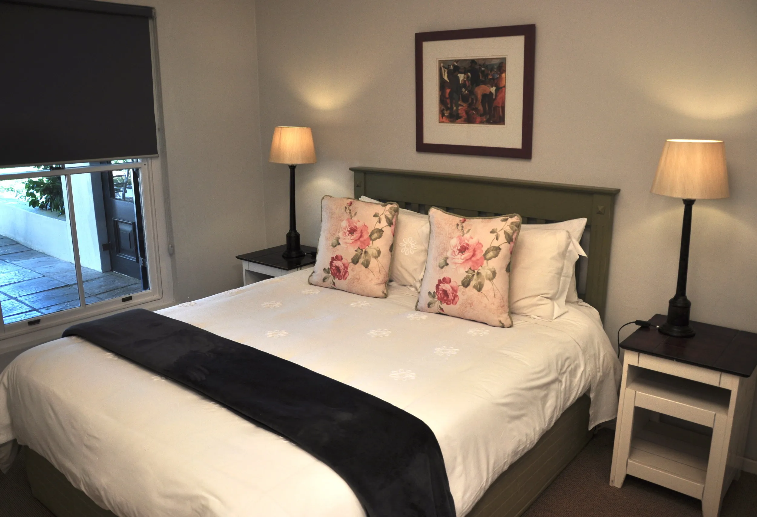 Cozy bedroom with a neatly made bed two bedside lamps and a window