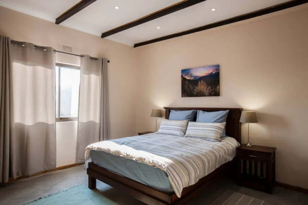 Cozy bedroom with a double bed bedside tables and a nature painting