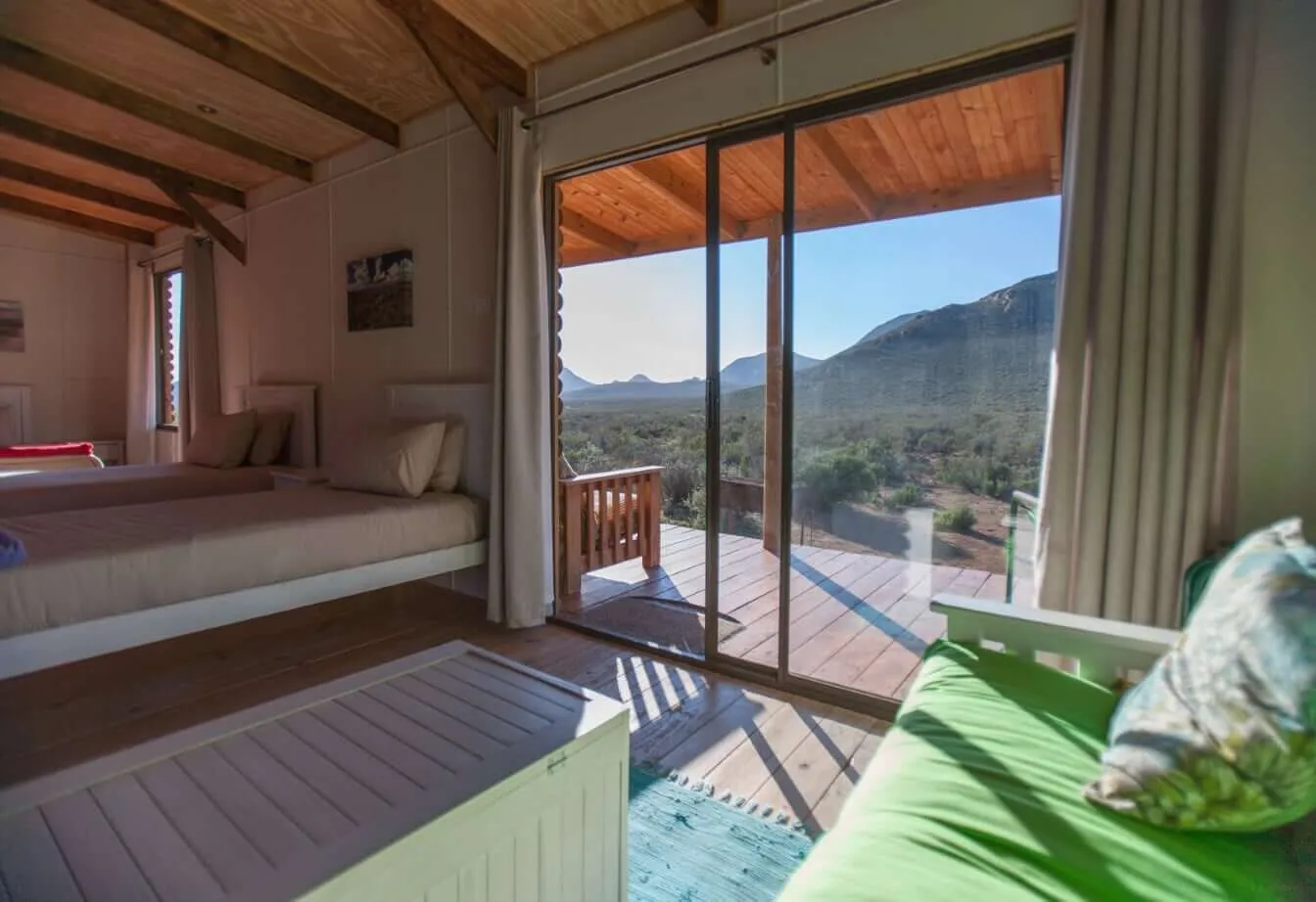 Cozy room with large window view of mountains and wooden deck