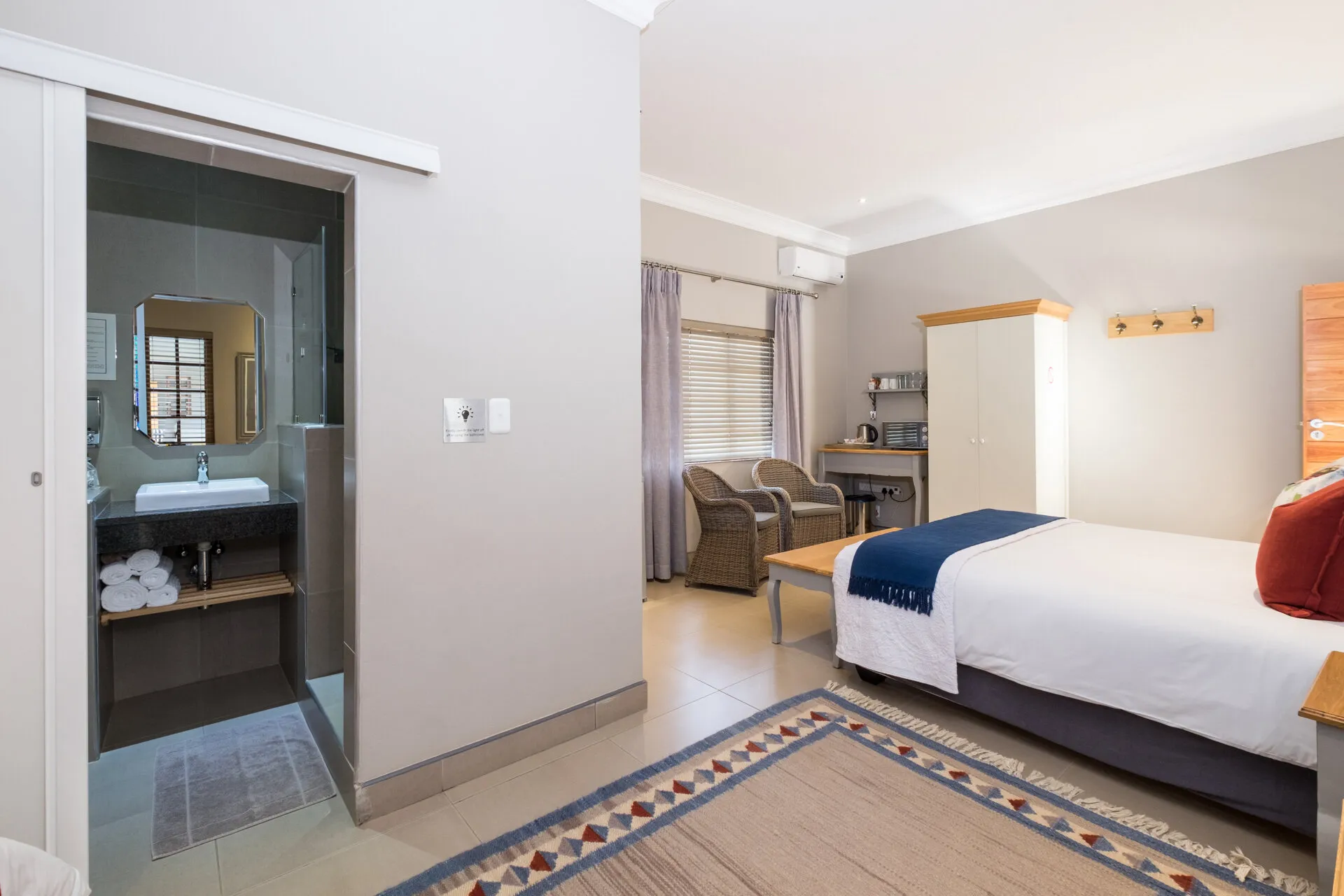 Modern hotel room with a bed desk and open bathroom area