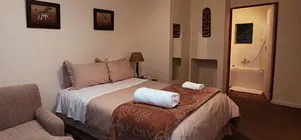 Cozy bedroom with a bed sofa and an open bathroom door