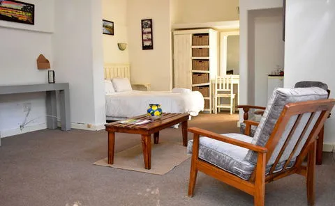 Cozy bedroom with wooden furniture armchair and a bed in the background