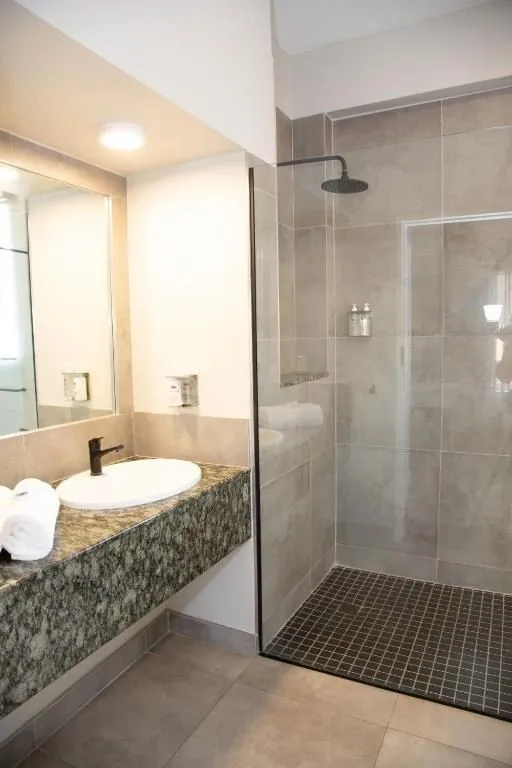 Modern bathroom with sink mirror and walkin shower with glass door