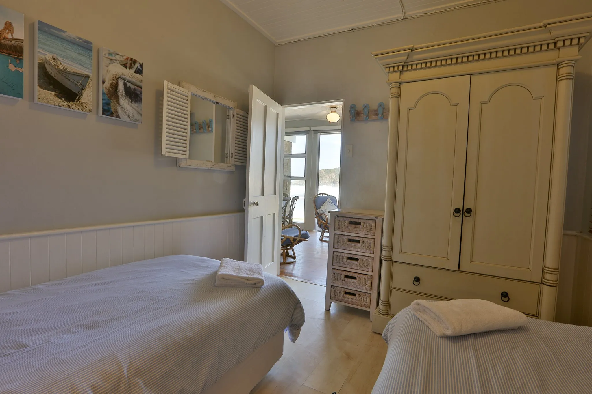 Bedroom with two single beds wardrobe and open door leading to a patio