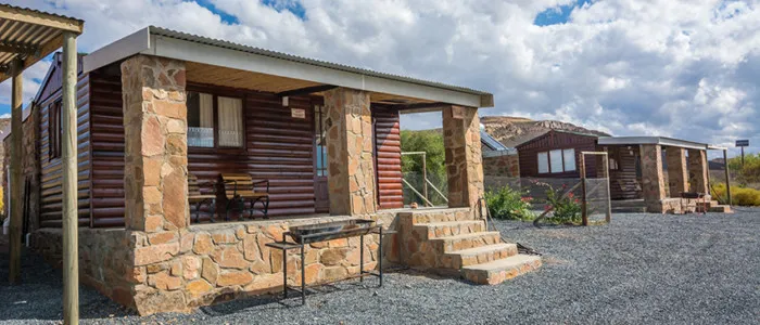 Stone and wood cabins with covered porches in a mountainous area