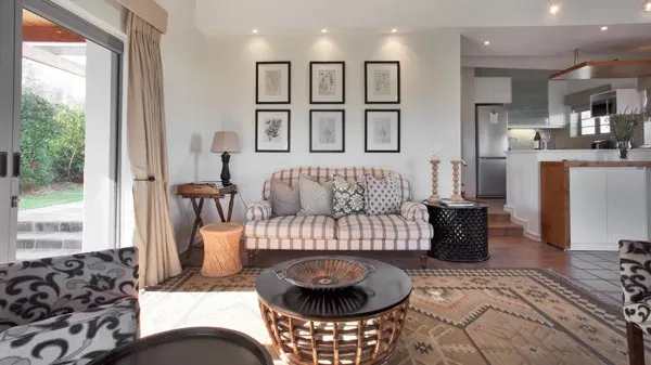 Living room with striped sofa patterned rug and open kitchen view
