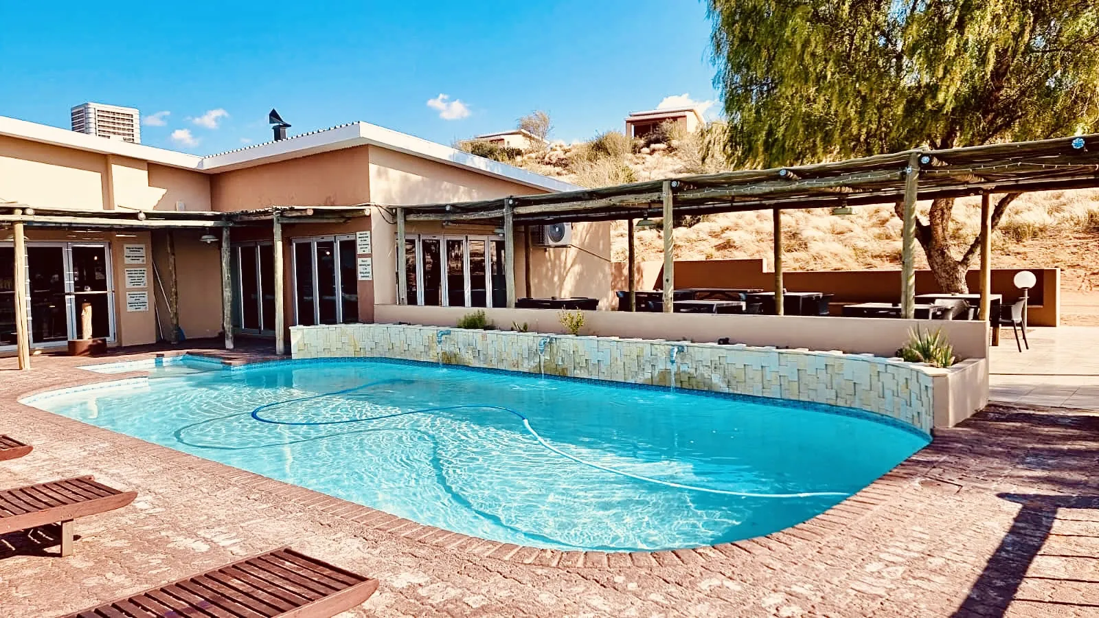 Swimming pool with lounge chairs at a sunny outdoor resort