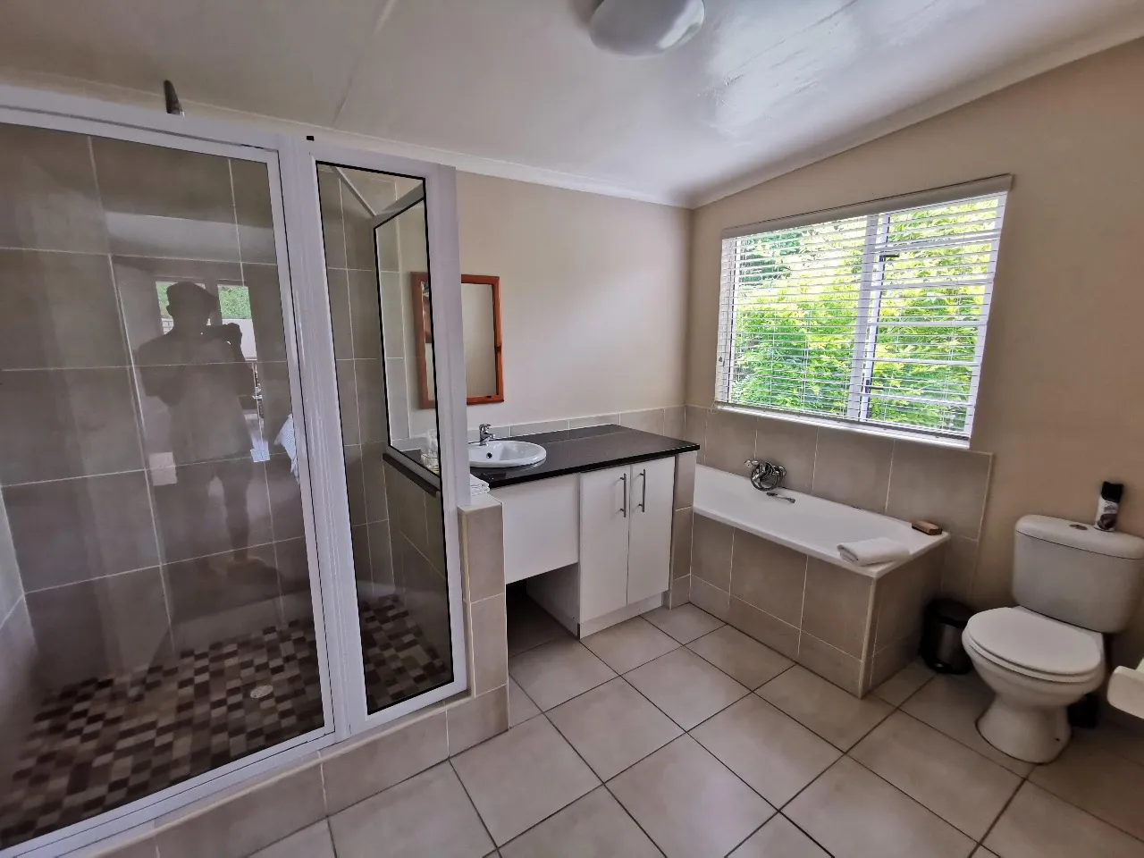 Modern bathroom with shower sink toilet and bathtub with a window view