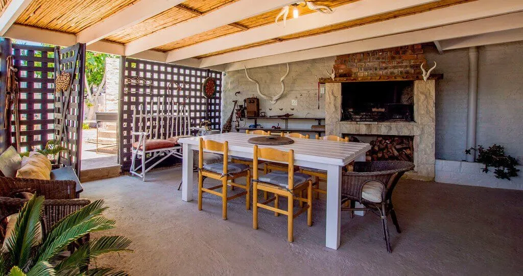 Outdoor patio with dining table chairs and a builtin barbecue fireplace