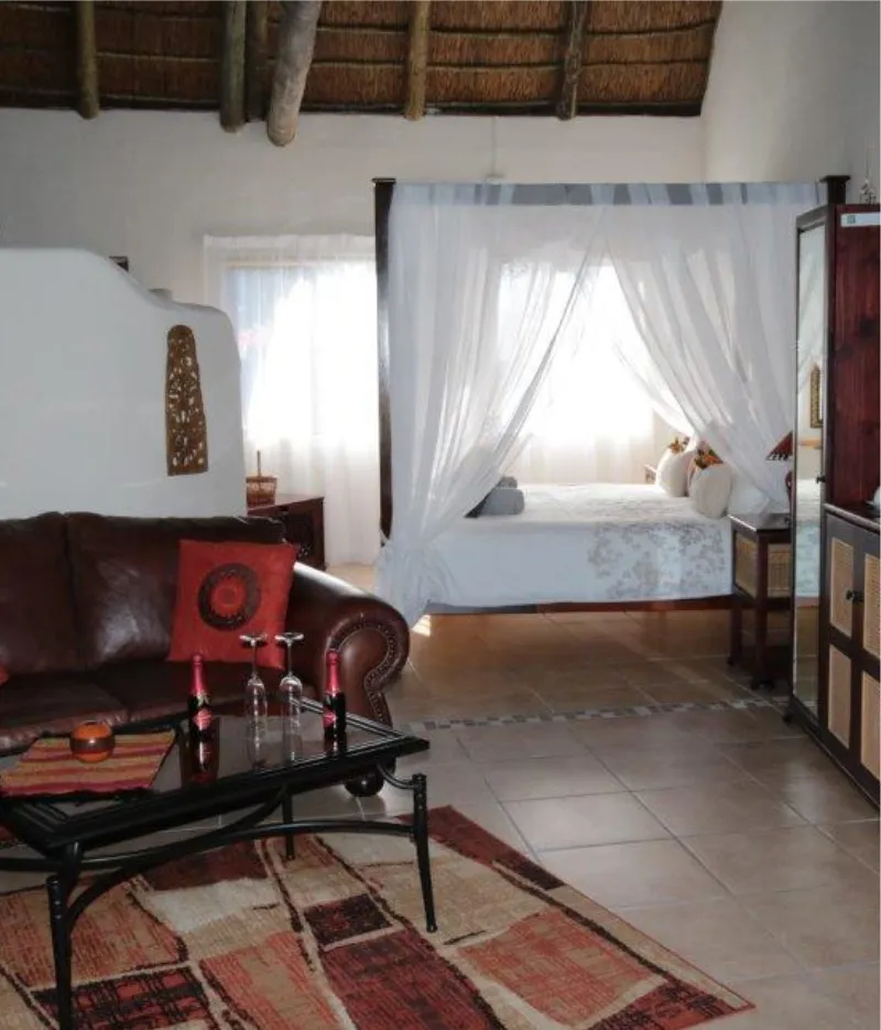 Cozy living room with sofa coffee table and view of bedroom with canopy bed