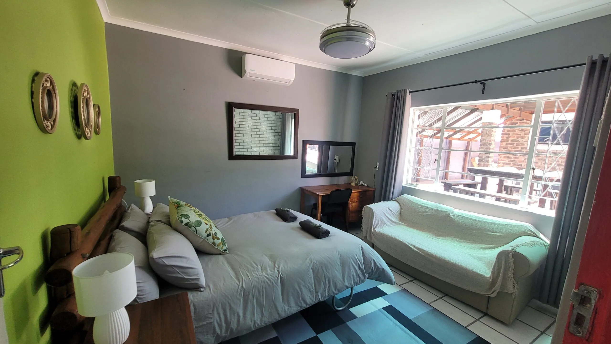 Bedroom with bed sofa TV and window view of an outdoor area