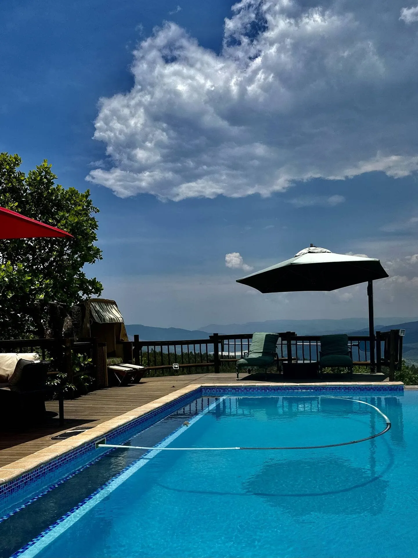 Swimming pool with lounge chairs and umbrellas scenic view cloudy sky