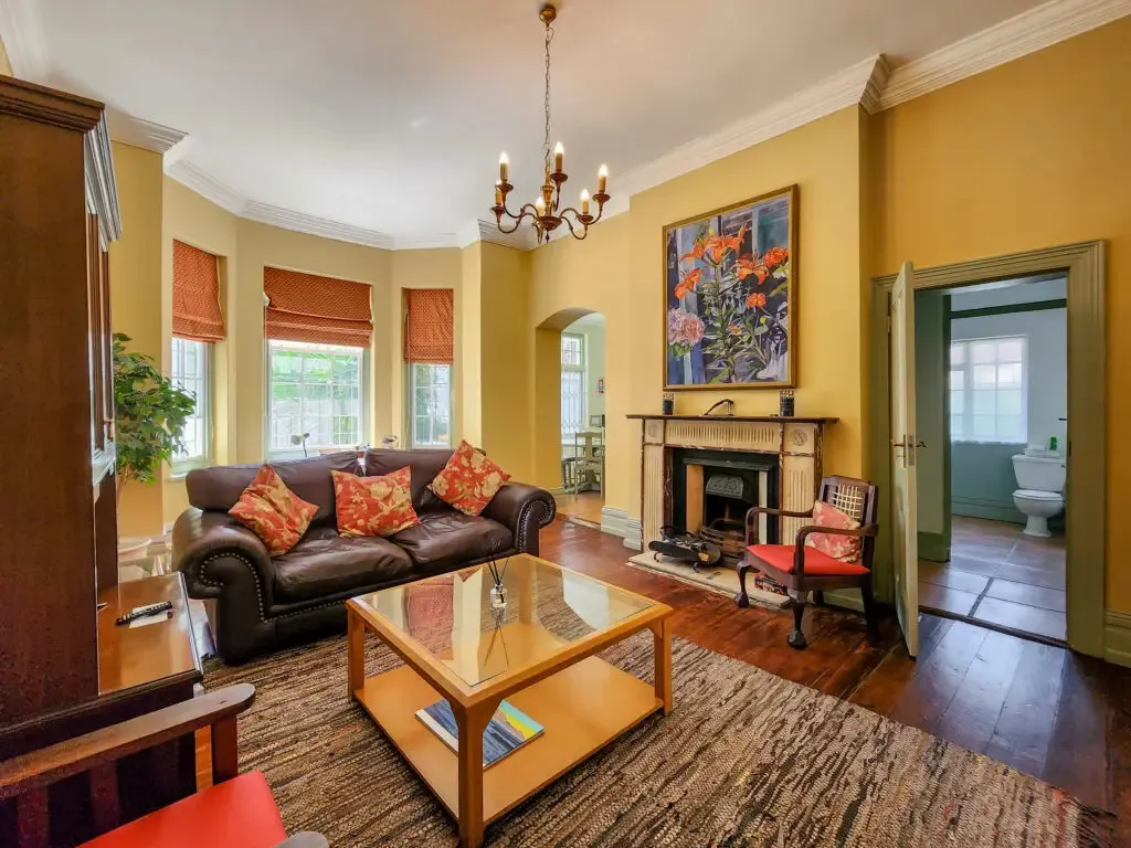 Cozy living room with brown sofa fireplace and large floral painting