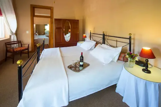 Cozy bedroom with a large bed white linens and bedside tables with lamps