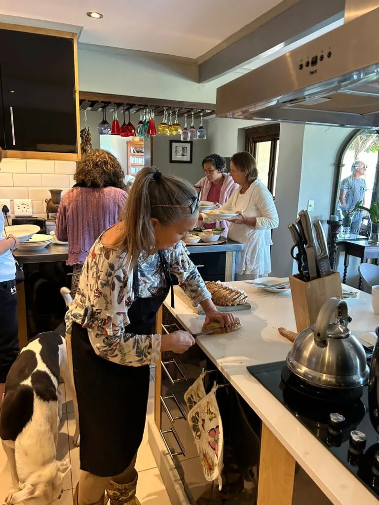 Woman preparing food in a kitchen with others in the background