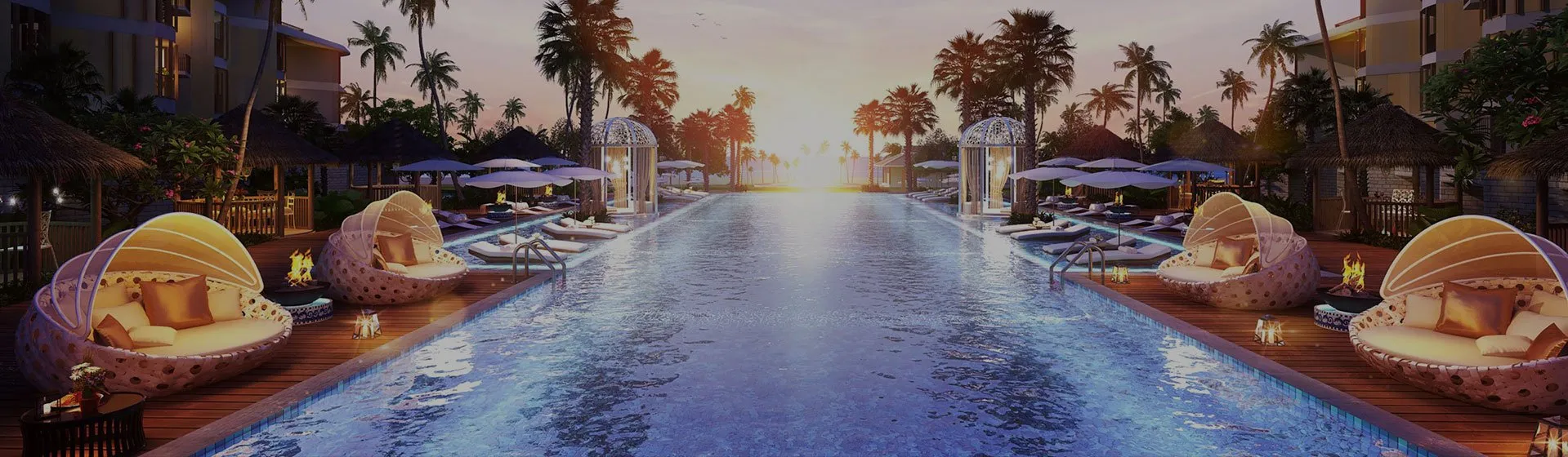 Tropical resort with palm trees lounge chairs and a long pool at sunset