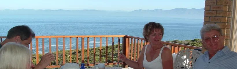 Four people dining with an ocean view on a sunny day